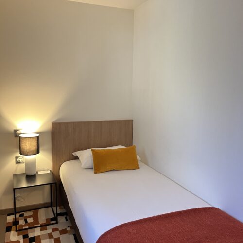 Lit simple dans la chambre triple
