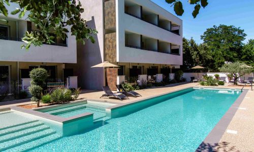 Piscine extérieure de Forme-Hôtel avec transats et vue sur le jardin