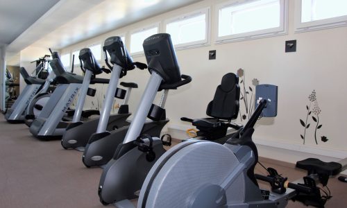 Salle de sport équipée à Forme-Hôtel avec des vélos elliptique